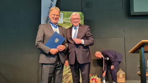 Peter Voss-Fels und Ministerpräsident Bouffier lächelnd nebeneinander bei der Verleihung des Verdienstordens.