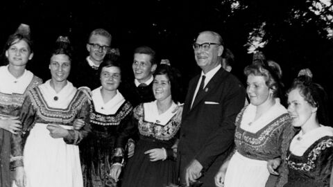 Schwarz-weiß-Aufnahme von Männern und Frauen in Festkleidung.